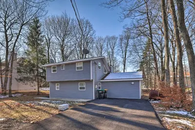 a gray house with a driveway in a yard at Hot Tub, Fire Pit and Game Room Tobyhanna Home! in Tobyhanna