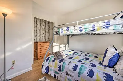 a bedroom with a double bunk bed with a bedspread at 4 Mi to Tobyhanna State Park Home with Fire Pit in Tobyhanna