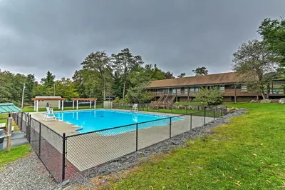 a fence around a swimming pool in a yard at 4 Mi to Tobyhanna State Park Home with Fire Pit in Tobyhanna