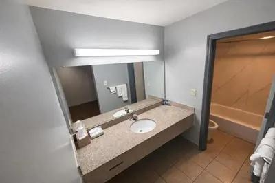 a bathroom with a sink and a mirror at King's Inn Motel in Reading