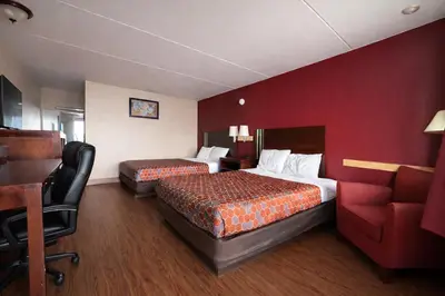 a hotel room with two beds and a red wall at King's Inn Motel in Reading