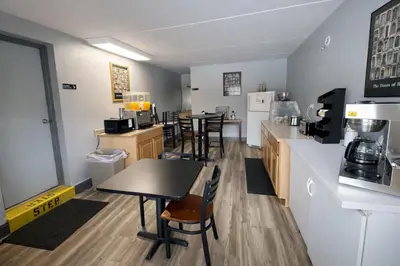 a kitchen with a table and chairs and a counter at King's Inn Motel in Reading
