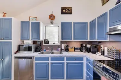 a kitchen with blue cabinets and a sink at Zen Den - Pocono LakeFront with Hot Tub ! in Pocono Summit