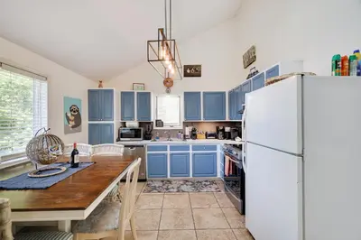 a kitchen with blue cabinets and a white refrigerator at Zen Den - Pocono LakeFront with Hot Tub ! in Pocono Summit