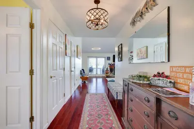 a hallway with a kitchen with a table and a rug at Zen Den - Pocono LakeFront with Hot Tub ! in Pocono Summit