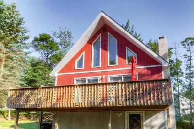 a red house with a balcony on top of it at Beautiful Chalet with Hot Tub & Sauna in Poconos in Long Pond