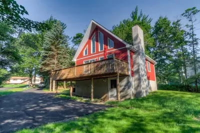 a large red barn with a gambrel roof at Beautiful Chalet with Hot Tub & Sauna in Poconos in Long Pond