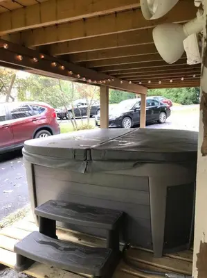 a bed in a patio with cars in a parking lot at Beautiful Chalet with Hot Tub & Sauna in Poconos in Long Pond
