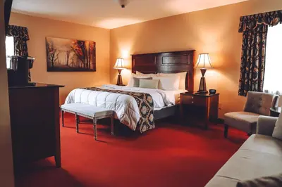 a hotel room with a bed and a chair at Tom Quick Inn in Milford