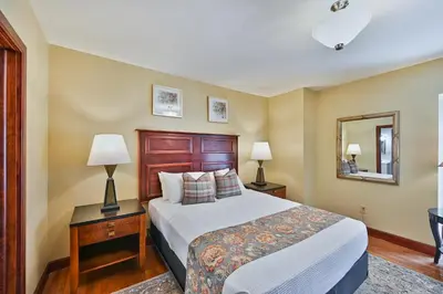 a bedroom with a bed and two lamps and a mirror at Tom Quick Inn in Milford