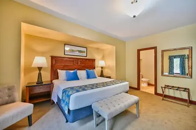 a bedroom with a large bed and a chair at Tom Quick Inn in Milford