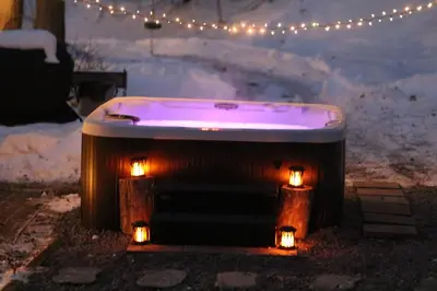 a hot tub with lights in the snow at Escape in our Rain-Forest A-Frame Retreat with Hot Tub at The Kairos Cabin in Harveys Lake