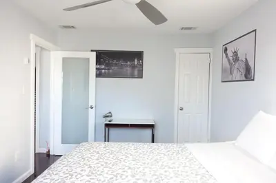 a white bedroom with a bed and a desk at Best Home To Visit NYC+Hot Tub+EWR Airport+Free Parking in Hillside
