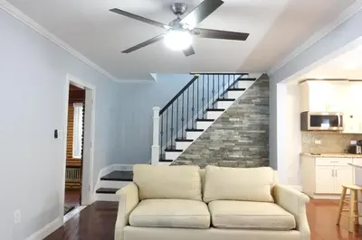 a living room with a couch and a ceiling fan at Best Home To Visit NYC+Hot Tub+EWR Airport+Free Parking in Hillside