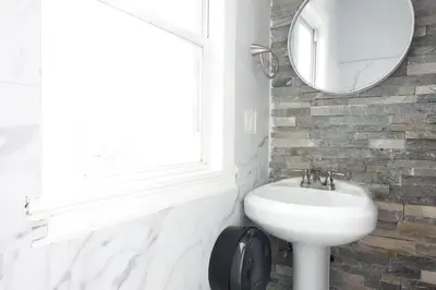 a white bathroom with a sink and a mirror at Best Home To Visit NYC+Hot Tub+EWR Airport+Free Parking in Hillside