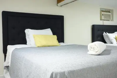 a bedroom with a large bed with a yellow pillow at Best EWR Airport Studio-Hot Tub-Free Parking in Hillside