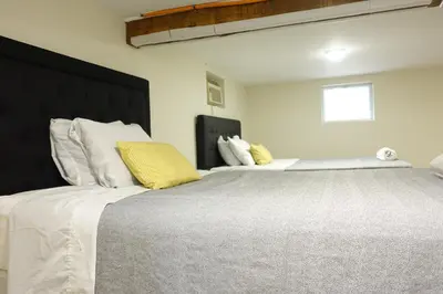 a bedroom with two beds with white and yellow pillows at Best EWR Airport Studio-Hot Tub-Free Parking in Hillside