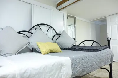 a bedroom with two beds and a mirror at Best EWR Airport Studio-Hot Tub-Free Parking in Hillside