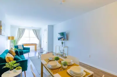 a living room with a table and a blue couch at Book Cozy King Bed Now 25 Percent OFF Spring Special! in Carteret