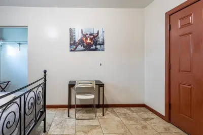 a table and a chair in a room with a door at 1 Bus Stop To NYC-Hot Tub-EWR Airport-Free Parking in Hillside