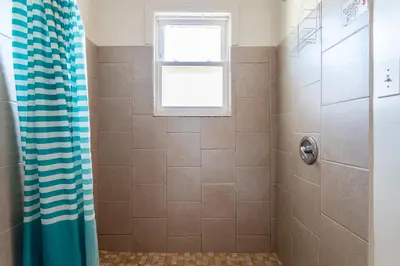 a shower with a blue shower curtain in a bathroom at 1 Bus Stop To NYC-Hot Tub-EWR Airport-Free Parking in Hillside