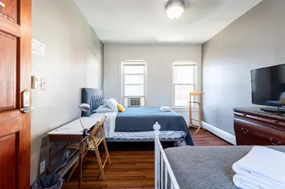 a room with two beds and a flat screen tv at Best Room To Visit NYC-Subway Access in Newark