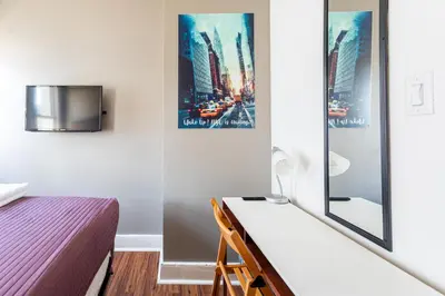 a small bedroom with a bed and a tv at Best Room To Visit NYC-Subway Access in Newark