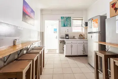 a kitchen with wooden benches and a white refrigerator at Best Room To Visit NYC-Subway Access in Newark