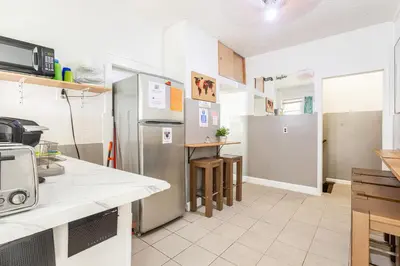 a kitchen with a refrigerator and a table in it at Best Room To Visit NYC-Subway Access in Newark