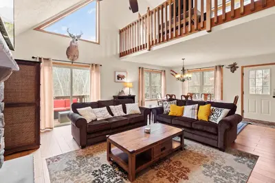 a living room with couches and a table at THE ONE Chalet in Albrightsville