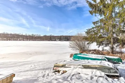 an old boat in the snow on a frozen lake at Private Lake Access and Canoes Pennsylvania Cottage in Lakewood