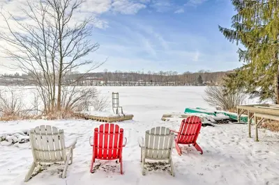 three red chairs and a table in the snow at Private Lake Access and Canoes Pennsylvania Cottage in Lakewood