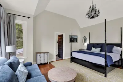 a bedroom with a bed and a blue couch at The South Mountain Inn in Wernersville