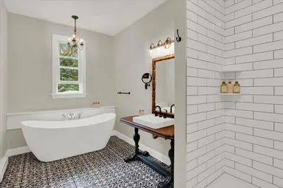 a white bathroom with a tub and a sink at The South Mountain Inn in Wernersville