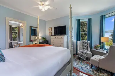 a bedroom with a large white bed and a tv at The South Mountain Inn in Wernersville