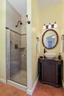 a bathroom with a shower and a sink and a mirror at The South Mountain Inn in Wernersville