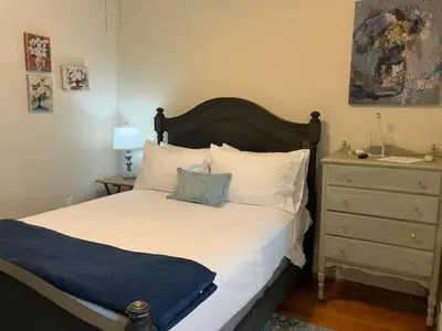 a bedroom with a bed and a dresser with a blue blanket at The South Mountain Inn in Wernersville