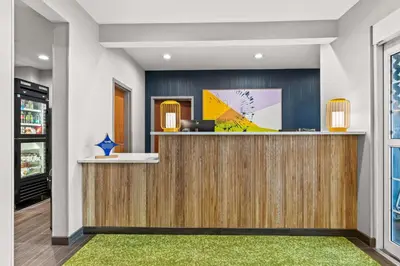 a lobby with a reception desk with a green rug at Spark By Hilton Hershey Near The Park in Hershey