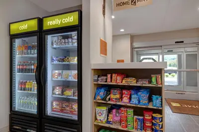 a convenience store with a refrigerator and shelves of food at Home2 Suites By Hilton Wilkes-Barre in Wilkes-Barre