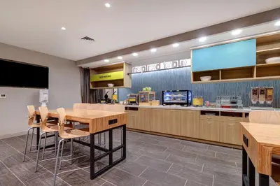 a dining room with a table and a large screen at Home2 Suites By Hilton Wilkes-Barre in Wilkes-Barre