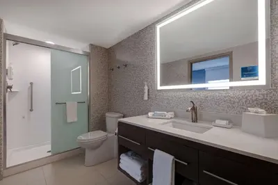 a bathroom with a sink and a toilet and a mirror at Home2 Suites By Hilton Wilkes-Barre in Wilkes-Barre