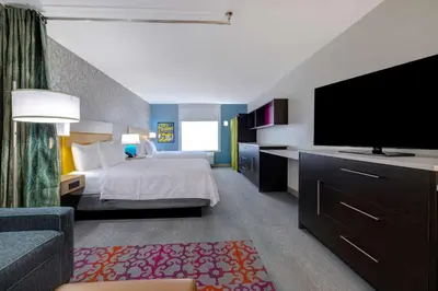 a hotel room with a bed and a flat screen tv at Home2 Suites By Hilton Wilkes-Barre in Wilkes-Barre