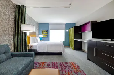 a hotel room with a bed and a flat screen tv at Home2 Suites By Hilton Wilkes-Barre in Wilkes-Barre