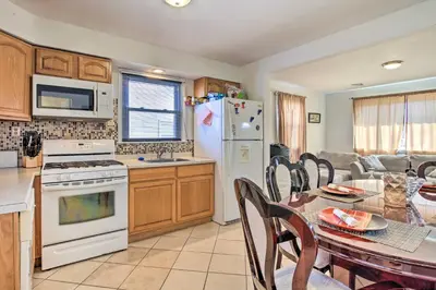 a kitchen and dining room with a table and a refrigerator at House with Pellet Smoker and Grill, 1 Mi to Lake! in Bellmawr