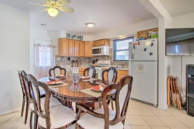 a kitchen with a table and chairs and a refrigerator at House with Pellet Smoker and Grill, 1 Mi to Lake! in Bellmawr