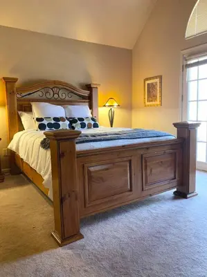 a bedroom with a large bed with a wooden frame at NEW Contemporary Chalet 5 Bed/3 Bath in Split Rock in Lake Harmony
