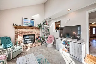 a living room with a brick fireplace and a television at East Earl Retreat with Hot Tub Less Than 4 Mi to Town! in East Earl