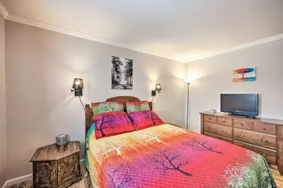 a bedroom with a bed and a flat screen tv at East Earl Retreat with Hot Tub Less Than 4 Mi to Town! in East Earl