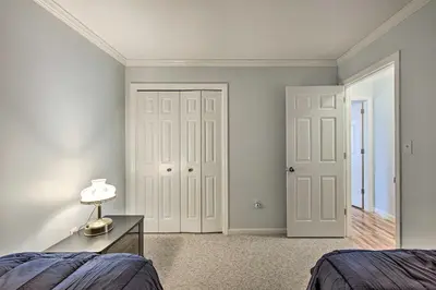 a bedroom with two doors and a table with a lamp at East Earl Retreat with Hot Tub Less Than 4 Mi to Town! in East Earl