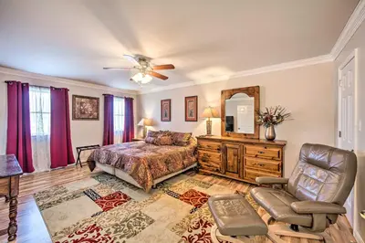 a bedroom with a bed and a mirror and a chair at East Earl Retreat with Hot Tub Less Than 4 Mi to Town! in East Earl